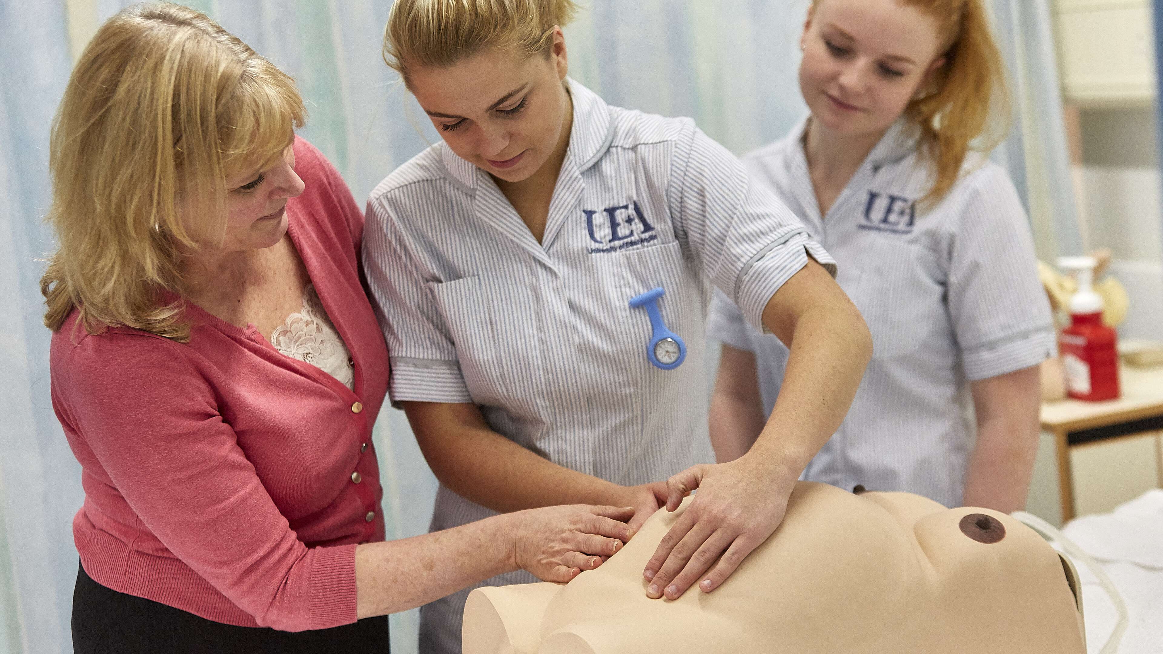 Midwifery students learning with model of pregnant person