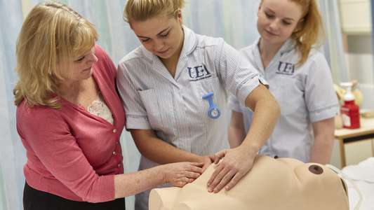 Midwifery students learning with model of pregnant person