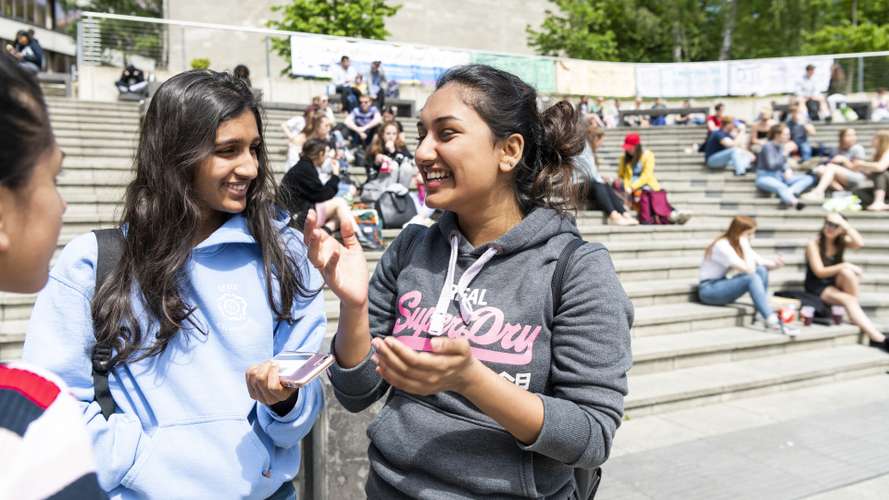 Students laughing at the Square on UEA campus