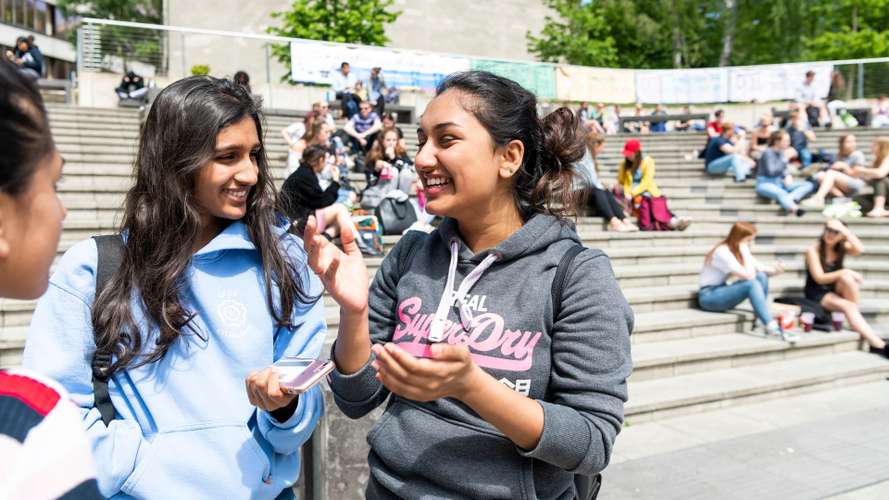 Students laughing at the Square on UEA campus