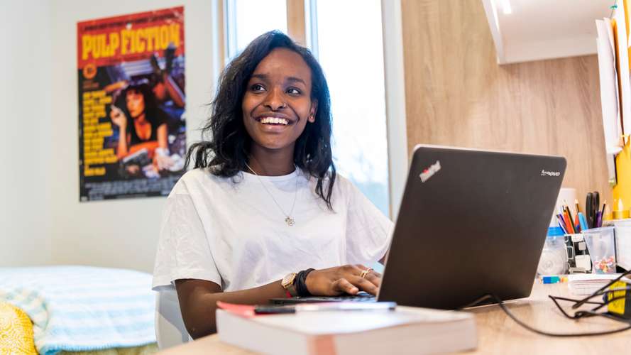 Student laptop at desk in campus bedroom