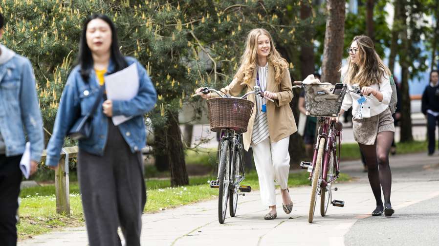 Students pushing their bikes together on campus
