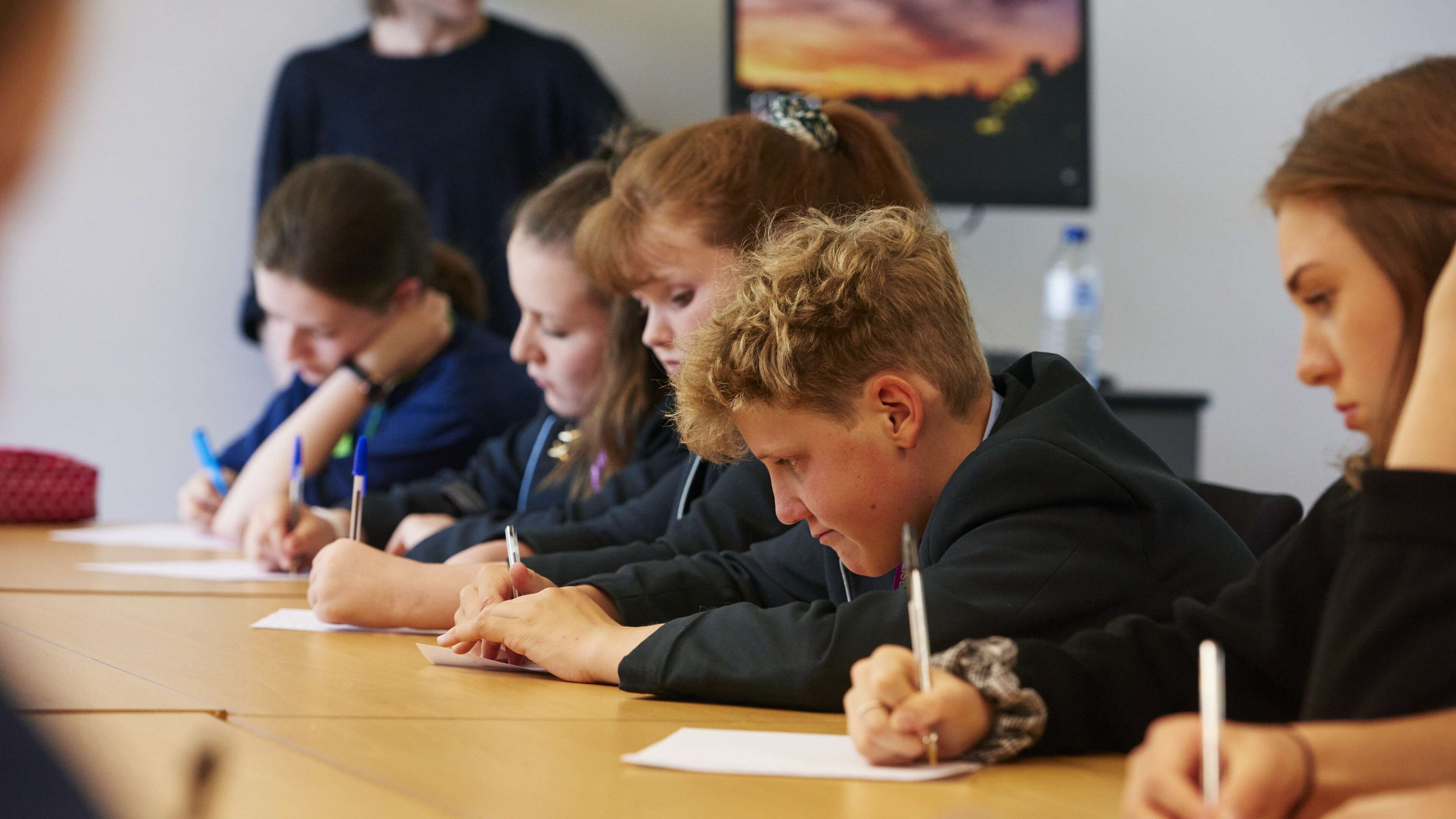 School students writing on paper