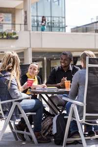 Four students sitting in Square talking