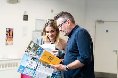 Student and carer looking through leaflets