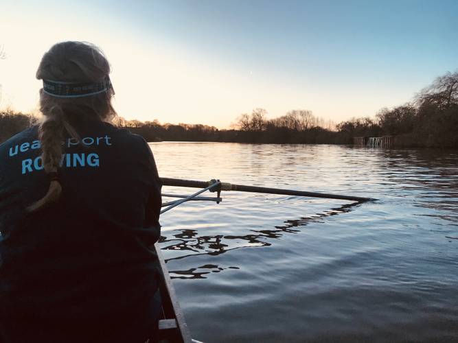 student rowing on lake - uea sport