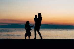 Silhouttes of a woman and children on a beach