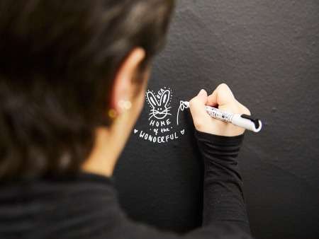 students-in-The-Warren-writing-home-of-the-wonderful-in-white-pen-on-a-black-wall_timeline-51623