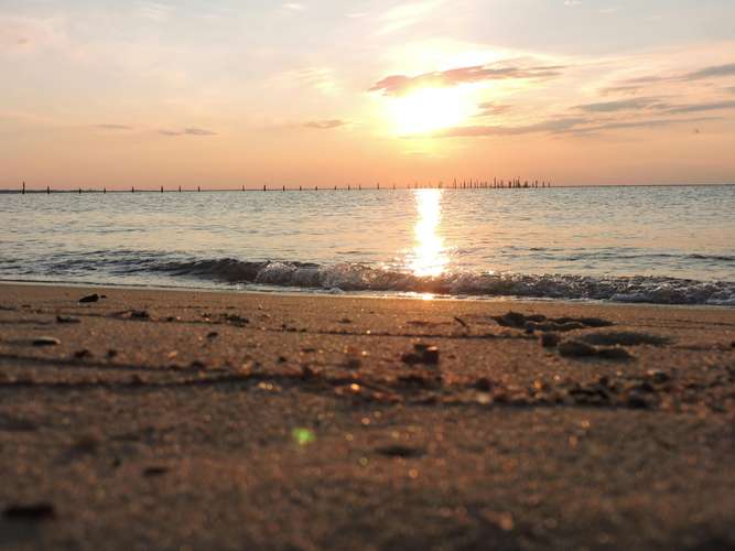 View across beach and sea as sun goes down