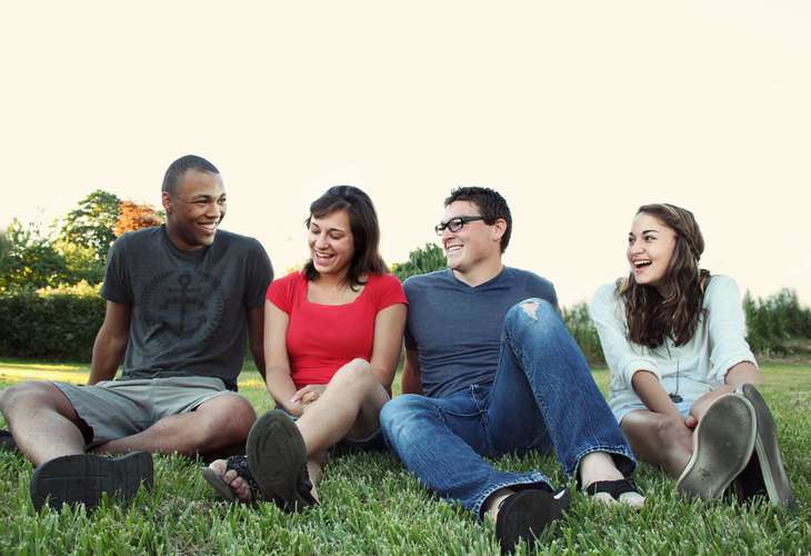 4 people sitting on grass