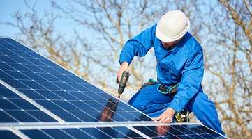 Man installing solar panels on a roof