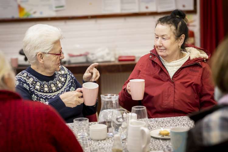Two women having a discussion whilst holding lovely cups of tea