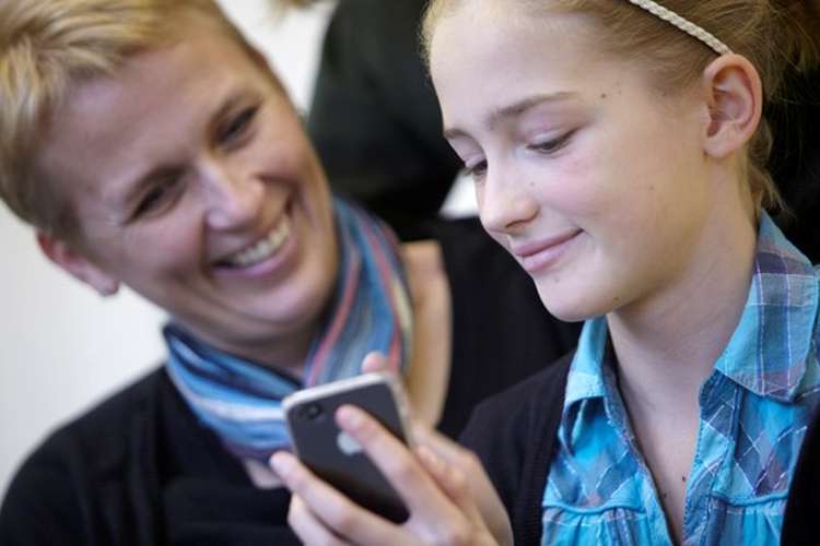 Woman and girl looking at mobile phone