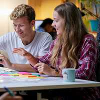 Two students sitting side by side working together