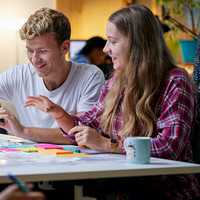 Two students sitting side by side working together