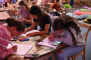 People sitting at a table and sketching.