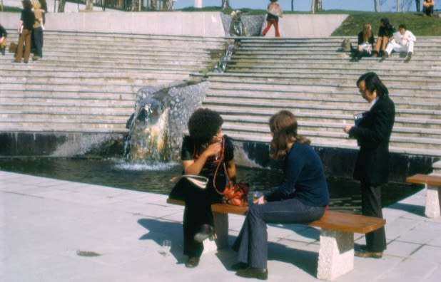 Students sat in the UEA Square, with a waterfall in the centre