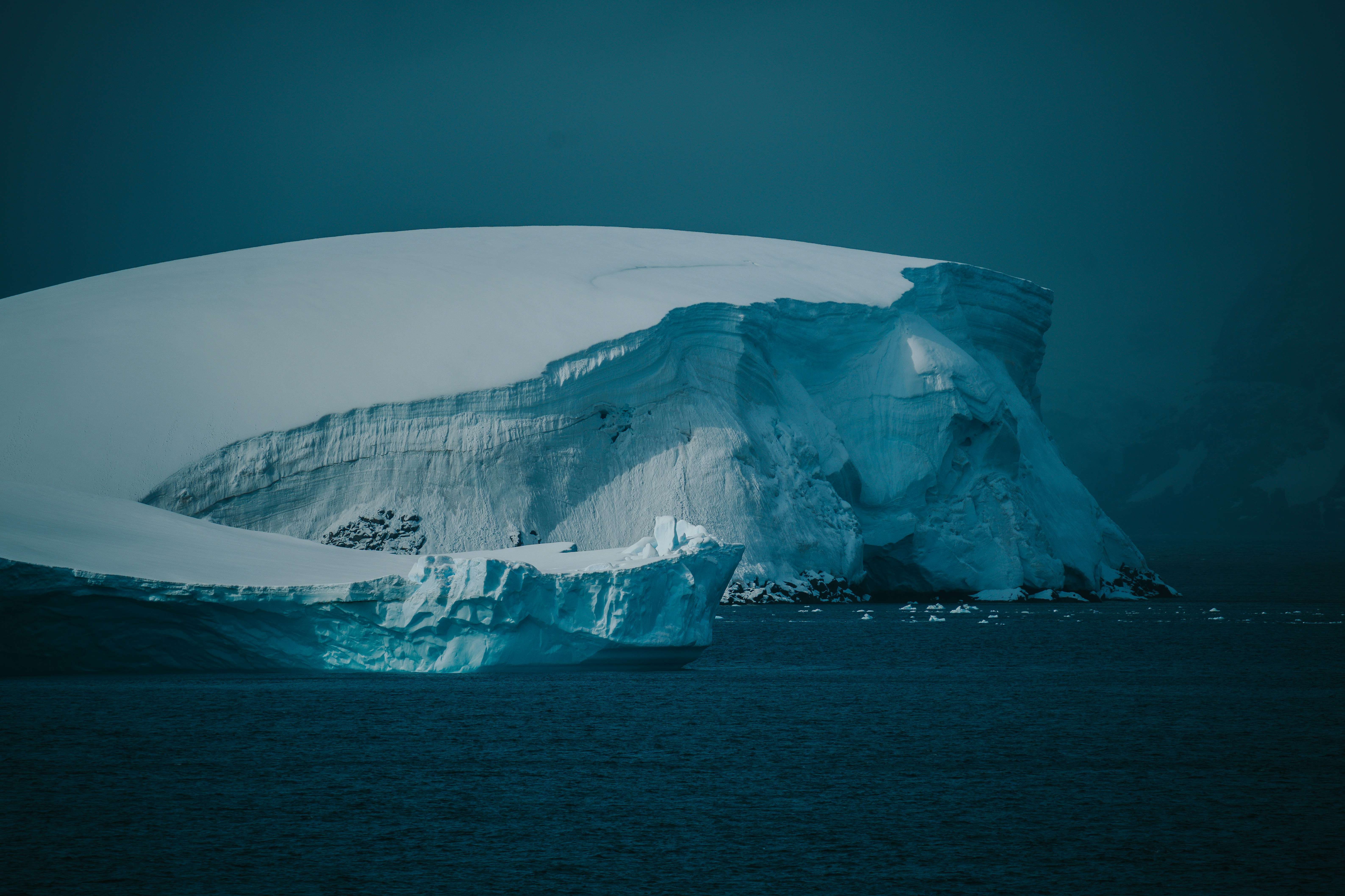 Iceberg floats in the cold, dark ocean water.