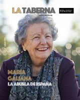 The cover of Issue 11 of the La Taberna magazine featuring an image of a smiling older woman with grey hair wearing a navy jacket and a scarf