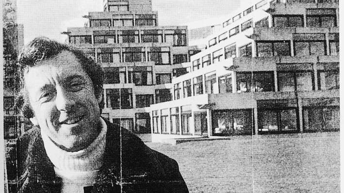 young Malcolm Bradbury smiling into the camera with the Ziggurats in the background