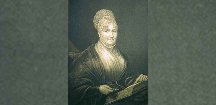 An engraving of a woman holding a book.