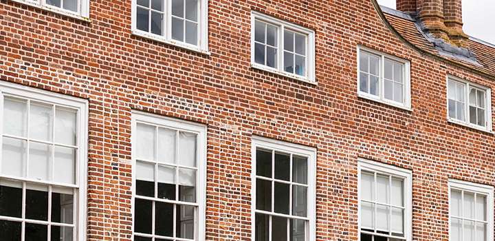 A double row of windows across a red brick building.