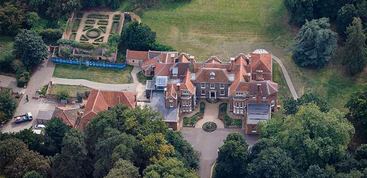 An aerial view of a building and large, green grounds surrounding it.