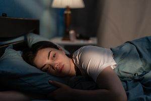 A woman lying in bed awake.