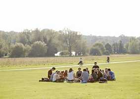 group of students sitting outside near lake