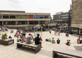 The square on campus with people sitting along the steps