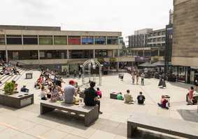 The square on campus with people sitting along the steps