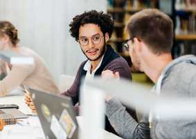 Male tutor helping student at computer