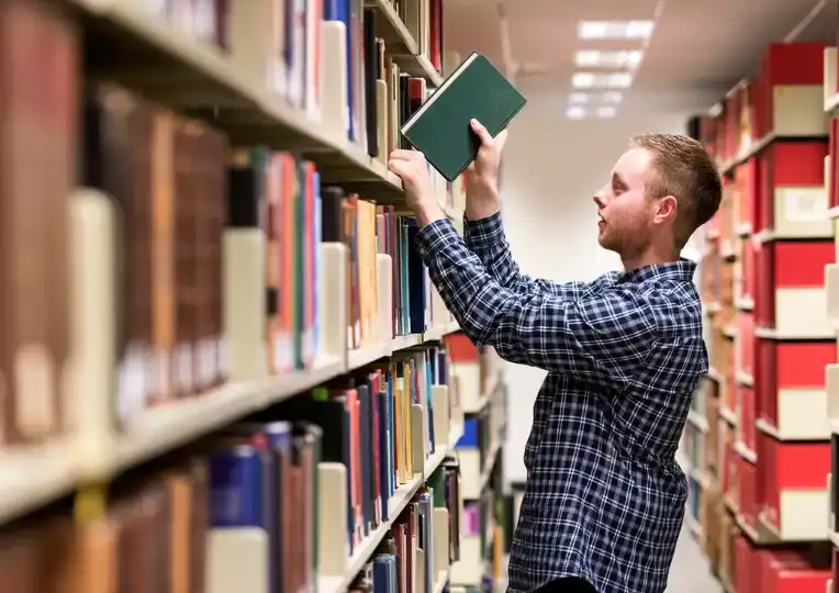 Student in library with book