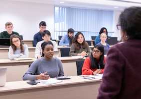 Economics-lecturer-speaking-to-group-of-students