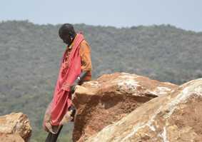 Indigenous woman leaning on a rock in the mountains