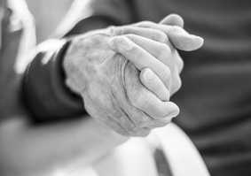 Black and white photo of two people holding hands