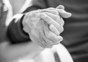 Black and white photo of two people holding hands