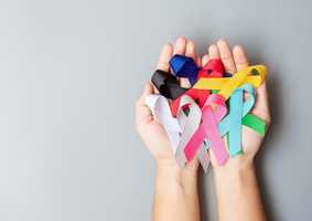 Hands holding cancer support ribbons