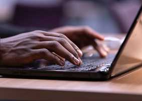 close up of hands typing on a laptop
