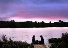 image of two people sitting next to The Broad at sunset