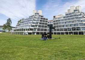 student sitting on statue outside Ziggurat buildings