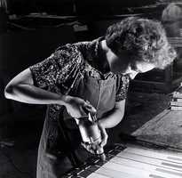 A factory worker drilling pilot holes. The photo is black and white.