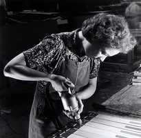 A factory worker drilling pilot holes. The photo is black and white.