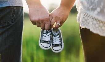 two people hold pair of small shoes
