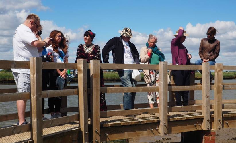 A group meets on the bridge at Burgh Castle