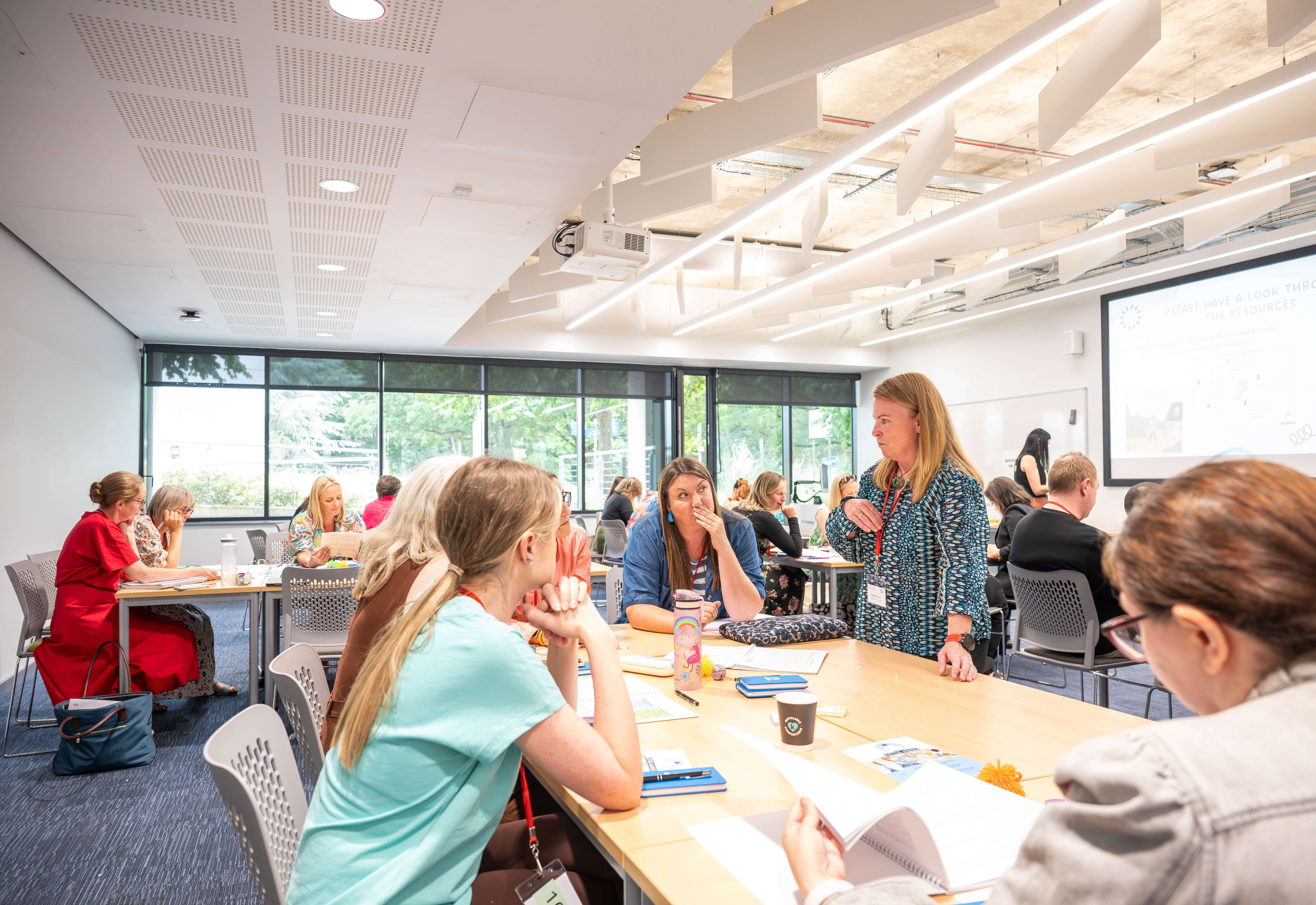 Postgraduate researchers and academics collaborating in a modern seminar room during a workshop at our Norwich campus.