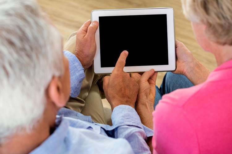 Two people looking at an electronic tablet with a blank screen