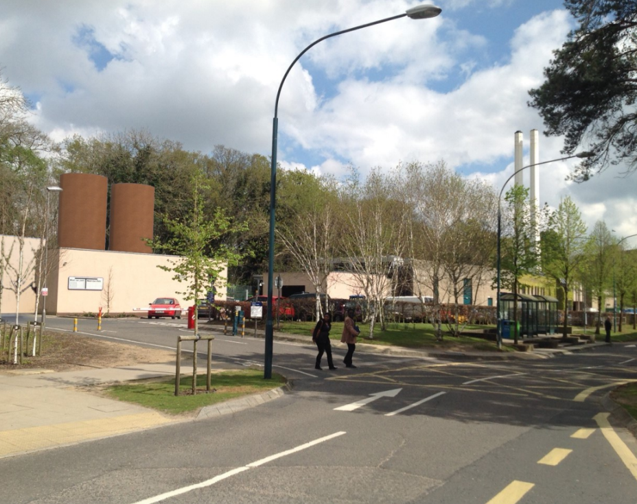 Street view containing a works building. A CGI image of two thermal stores is shown behind a building.