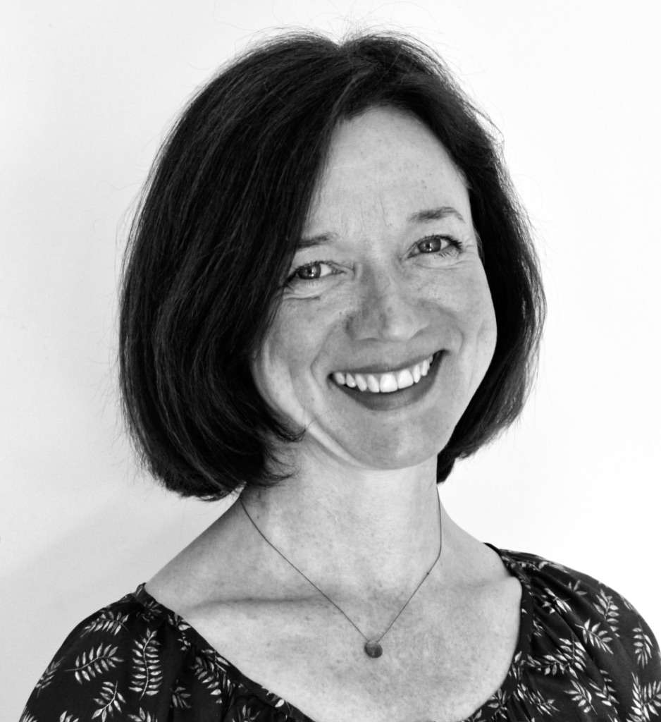 A black and white portrait photo of a smiling woman.