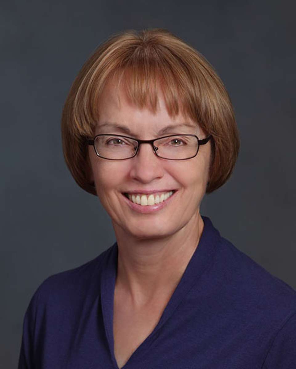 A portrait image of a woman smiling at the camera.